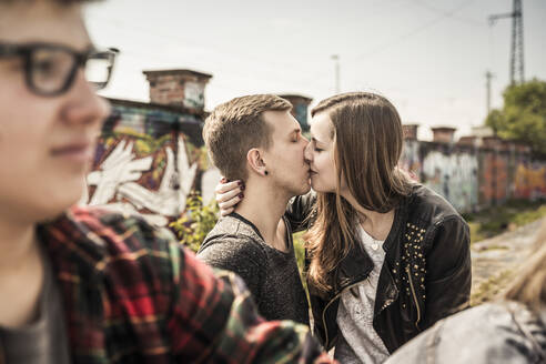 Teenagerpaar küsst sich in einem alten, heruntergekommenen Industriegebiet - DHEF00231