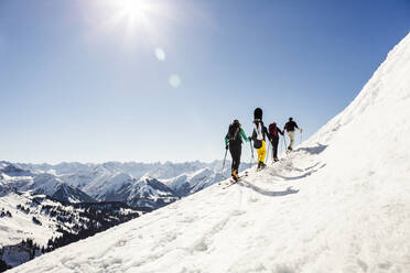 Gruppe von Freunden beim Skitourengehen auf einen Berggipfel, Achenkirch, Österreich - DHEF00249