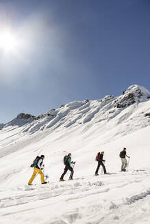 Gruppe von Freunden beim Skitourengehen auf einen Berggipfel, Achenkirch, Österreich - DHEF00258