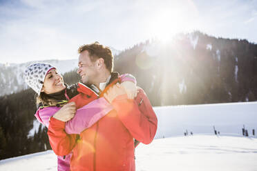 Sich umarmendes Paar in verschneiter Berglandschaft, Achenkirch, Österreich - DHEF00262