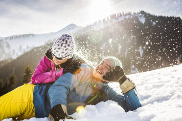 Sorgloses Paar im Schnee liegend - DHEF00272