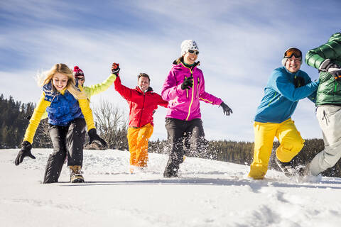 Gruppe unbeschwerter Freunde beim Laufen und Spaß haben im Schnee, Achenkirch, Österreich, lizenzfreies Stockfoto