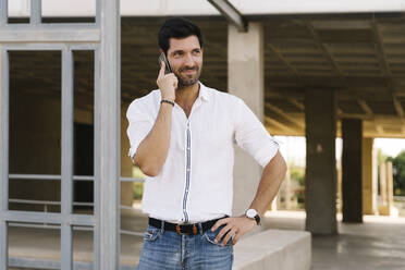 Smiling entrepreneur talking on phone in city - MPPF01024