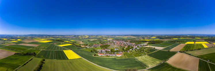 Germany, Hesse, Munzenberg, Helicopter view of countryside village surrounded by fields in summer - AMF08383