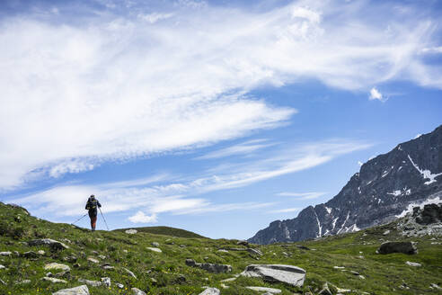 Mann beim Wandern auf einem Berg der westlichen Rätischen Alpen, Sondrio, Italien - MCVF00569