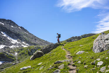 Man on hiking trail of mountain at Western Rhaetian Alps, Sondrio, Italy - MCVF00573