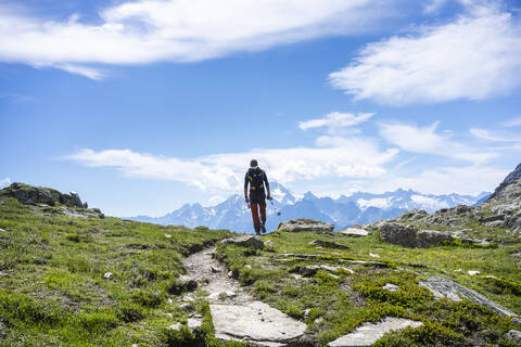 Mann beim Wandern auf einem Bergpfad in den westlichen Rätischen Alpen, Sondrio, Italien, lizenzfreies Stockfoto