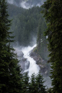 Sauberes Wasser, das von einer rauen Klippe an einem nebligen Tag in einer friedlichen Landschaft in Österreich fällt - ADSF10790