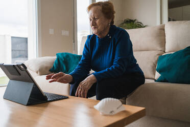 Alte Frau kommuniziert mit ihrer Tochter per Videochat auf dem Laptop - ADSF10820