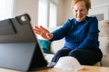 Ältere Frau kommuniziert mit einem Freund während eines Videochats auf einem Laptop - ADSF10824