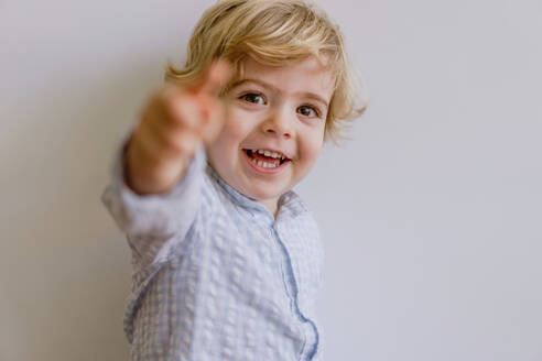 Adorable kleines Kind trägt lässig Shirt lächelnd und Blick auf die Kamera auf weißem Hintergrund des Studios - ADSF10921