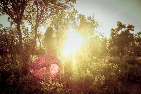 Junge Frau in einem langen Sommerkleid mitten im Wald - CAVF88180
