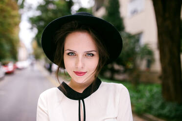 Porträt einer jungen, hübschen Frau mit schwarzem Hut - CAVF88184