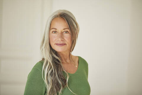 Confident mature woman standing at home stock photo