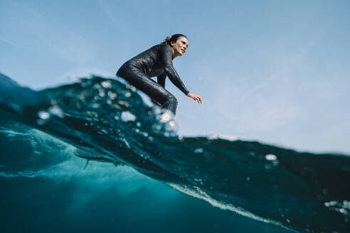 Close up split image of female surfer on a wave - CAVF88229