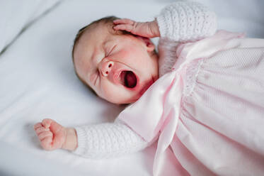 Hohe Winkel der entzückenden Baby-Mädchen in gemütlichen Kleid im Kinderbett liegend und gähnend im Schlaf - ADSF10966