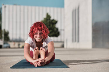 Healthy Beautiful Red Haired Woman Doing Yoga Exercises At Home On Floor,  Sitting On Mat In Lotus Position With Eyes Closed And Arms Up Breathing  Deeply And Relaxing Stock Photo, Picture and