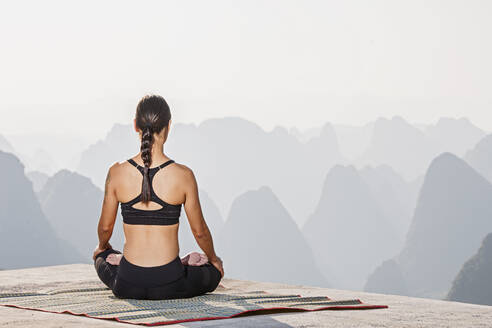 Schöne Frau beim Yoga oberhalb der kastigen Berge von Yangshuo - CAVF88256