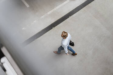 High angle view of businessman walking in city - DIGF12810