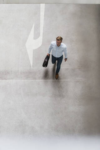 High angle view of businessman with bag walking in city stock photo