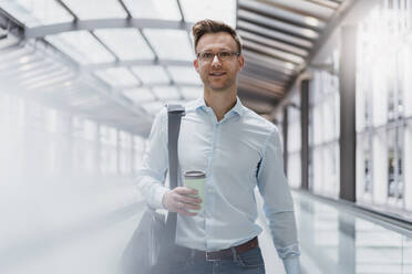 Geschäftsmann mit Kaffee beim Spaziergang in der Stadt - DIGF12815