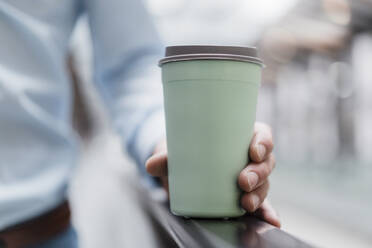 Close-up of businessman holding coffee in city - DIGF12816