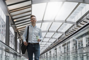 Businessman with coffee cup looking away in city - DIGF12820