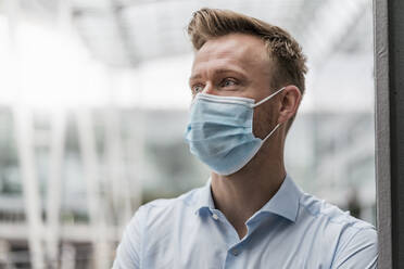 Businessman wearing mask in city during pandemic - DIGF12825