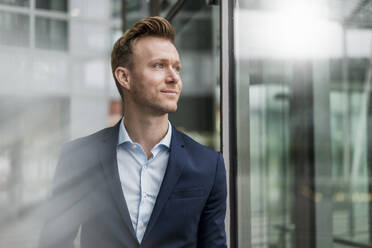 Confident businessman wearing suit looking away in city - DIGF12830