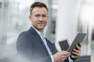 Selbstbewusster Geschäftsmann mit digitalem Tablet in der Stadt - DIGF12885