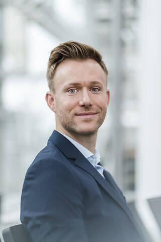 Smiling confident businessman sitting in city stock photo