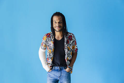 Man with fractured arm standing against blue background stock photo