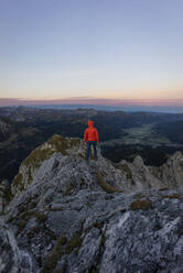 Rear view of hiker on viewpoint during sunrise, Gimpel, Tyrol, Austria - MALF00059