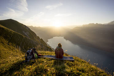 Wanderin auf Aussichtspunkt sitzend bei Sonnenuntergang, Augstmatthorn, Schweiz - MALF00077