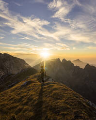 Female hiker walking to viewpoint during sunset, Hochplatte, Bavaria, Germany - MALF00080