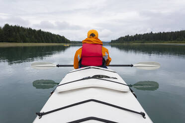 Woman sea kayaking calm waters of an inlet in a national park. - MINF15052