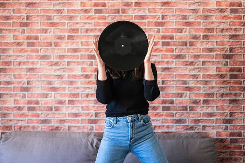 Anonyme junge Frau hält eine schwarze Schallplatte in den Händen - ADSF10997