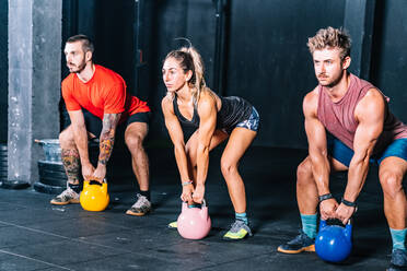 Athletische starke Burschen beim Training mit Gewichten in der Turnhalle - ADSF11150