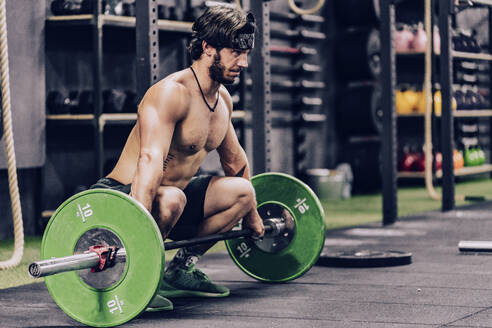 Starker und sportlicher Mann beim Langhanteltraining in einem modernen Fitnessstudio - ADSF11163