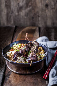 Schüssel mit verzehrfertigem Teriyaki-Reis mit Chinakohl und gegrillten Rindfleischspießchen - SBDF04306