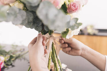 Hände eines männlichen Floristen bei der Vorbereitung eines Blumenstraußes - DSIF00082