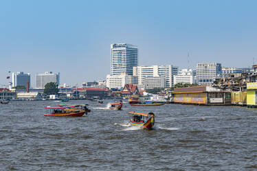 Thailand, Bangkok, Fähren auf dem Fluss Chao Phraya mit der Skyline der Stadt im Hintergrund - RUNF04066