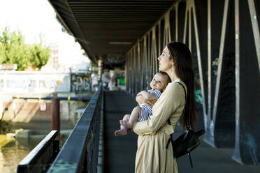 Mother with her baby boy on a bridge - IHF00382