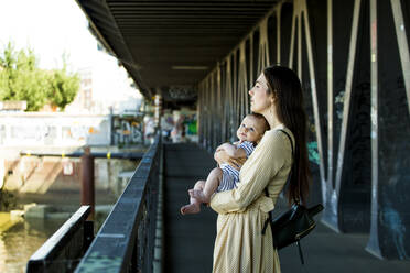 Mutter mit ihrem Baby auf einer Brücke - IHF00389