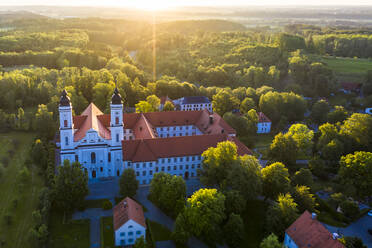 Deutschland, Bayern, Irsee, Blick aus dem Hubschrauber auf das Kloster Irsee bei Sonnenaufgang - AMF08395
