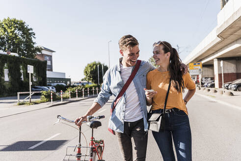 Glückliches junges Paar auf der Straße in der Stadt - UUF20869