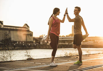 Freunde beim Sport mit verschränkten Händen am Hafen - UUF20984