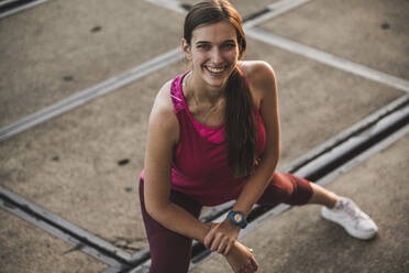 Smiling woman stretching at rails - UUF20989