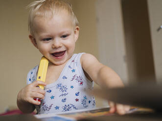 Nettes glückliches Baby spielt mit Bleistift zu Hause - KNTF05192