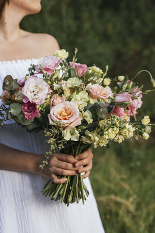 Frau hält Blumenstrauß aus frischen Blumen, lizenzfreies Stockfoto